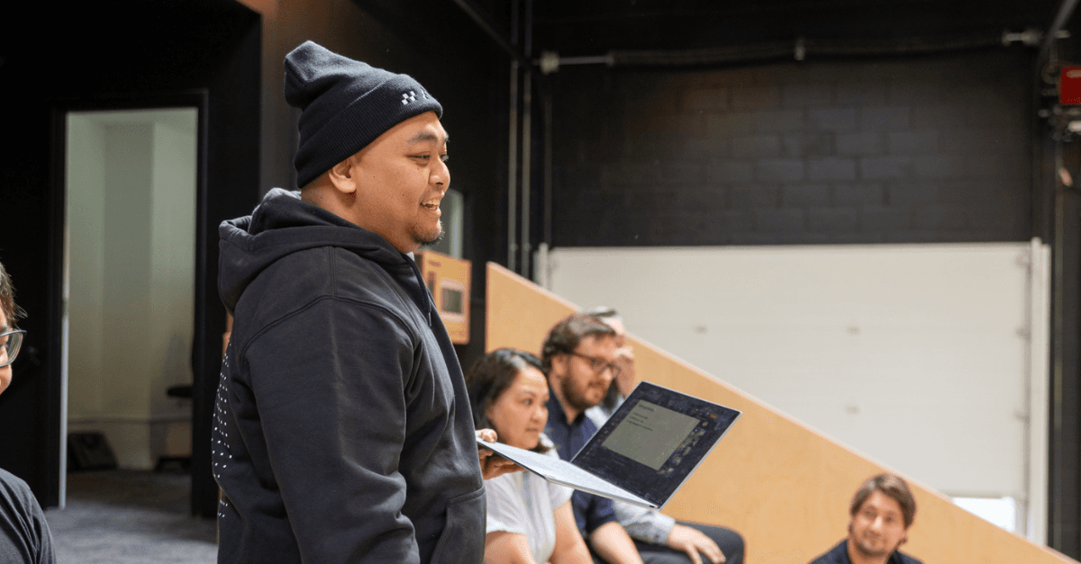 Man standing and presenting with a laptop